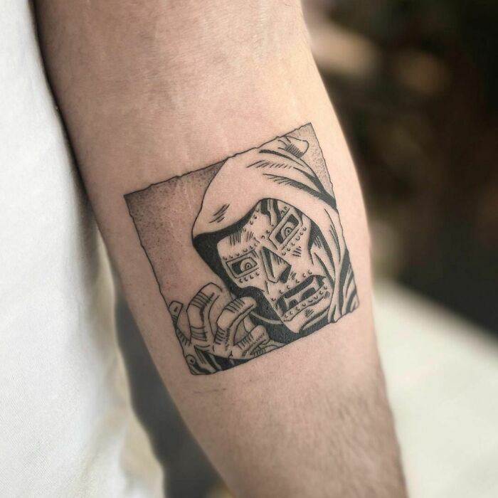 Marvel tattoo featuring detailed black and gray illustration on forearm.