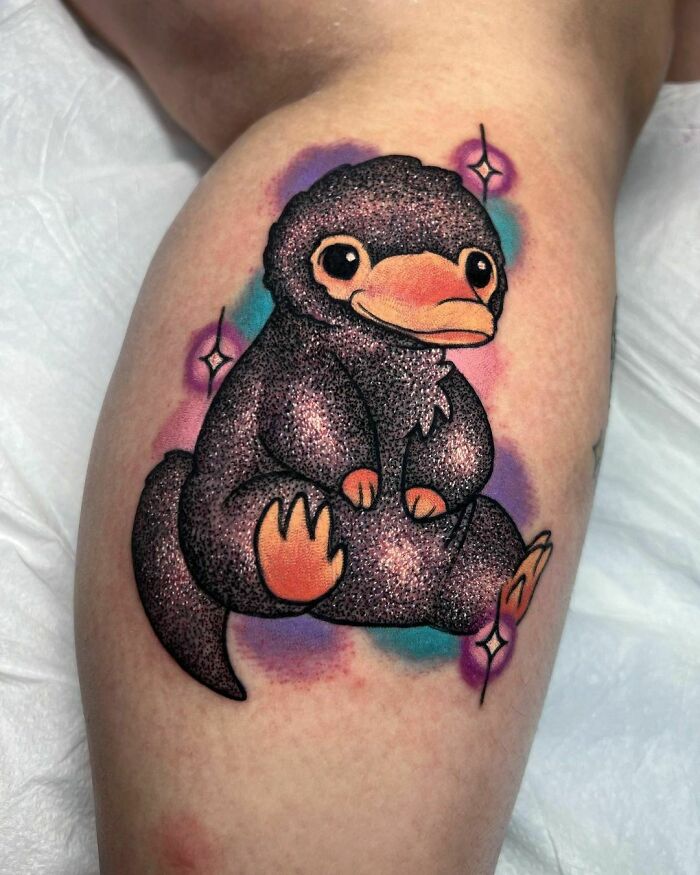 Glitter tattoo of a cute creature on skin, featuring sparkling colors and intricate details.
