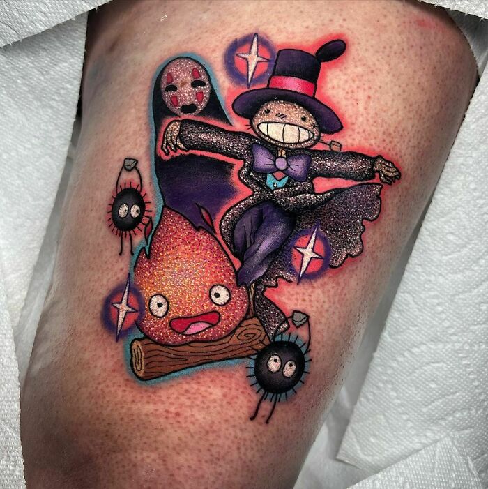 Colorful glitter tattoo featuring animated characters with a smiling scarecrow in a top hat and playful fire icon.