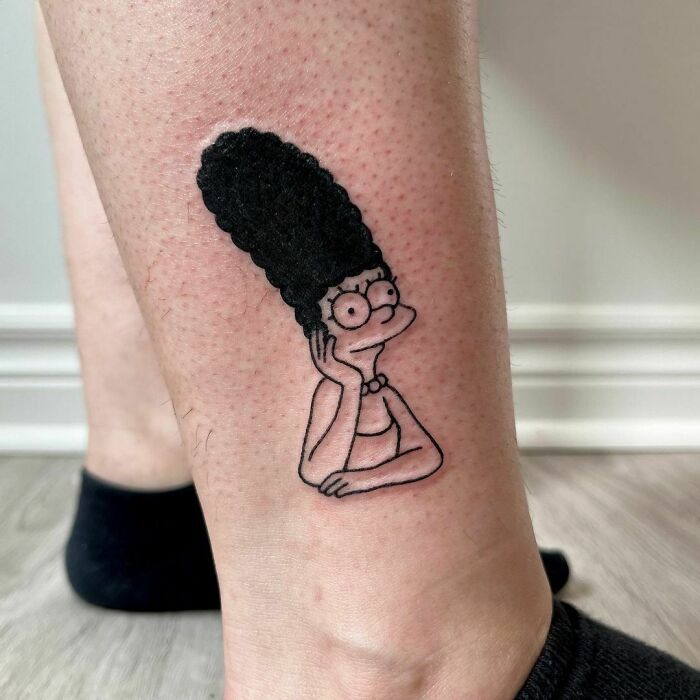 Cartoon tattoo of a character Marge with tall hair on an ankle, showcasing nostalgic design.