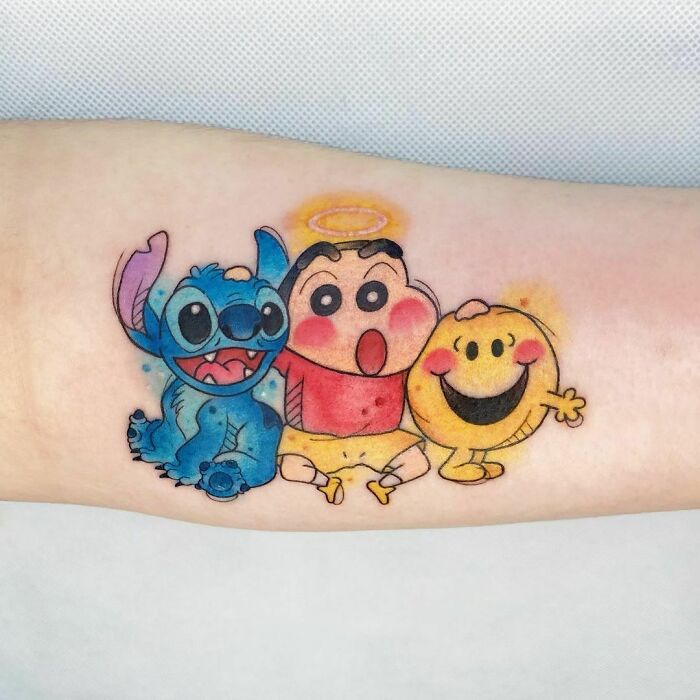Colorful cartoon tattoo featuring characters from popular animated shows on the arm.