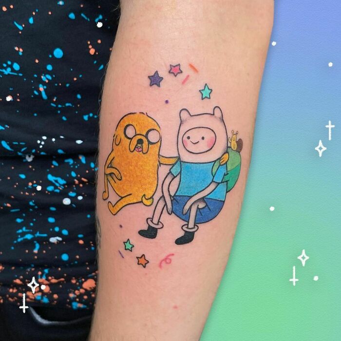 Cartoon tattoos featuring characters sitting together with colorful stars on arm.