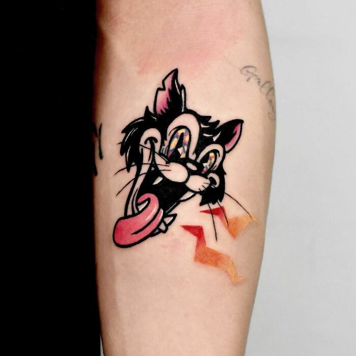 Cartoon tattoo featuring a playful Butch cat design on forearm, highlighting nostalgic art style.