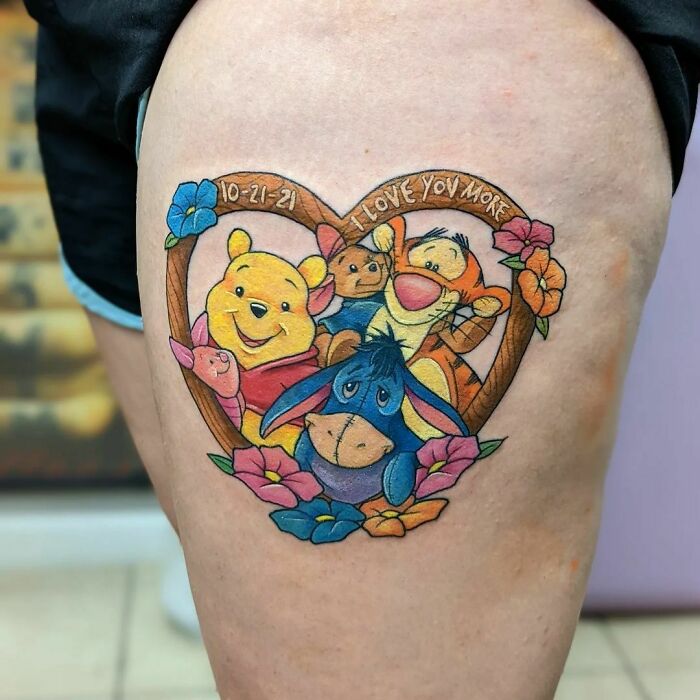 Cartoon tattoo of childhood favorites featuring classic bear and friends with heart and floral design.