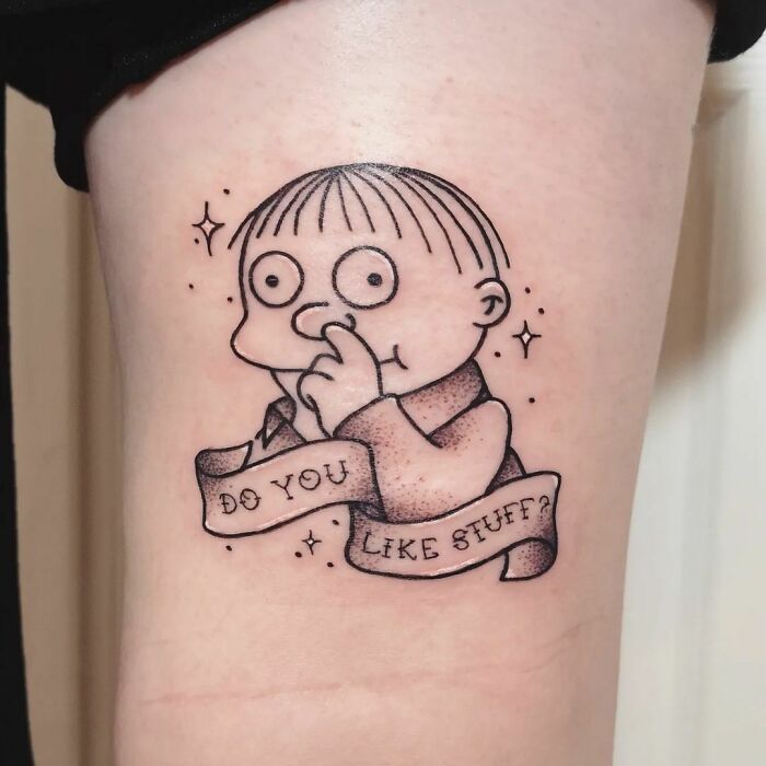 Cartoon tattoo of a character from an animated show with a banner saying "Do you like stuff?"