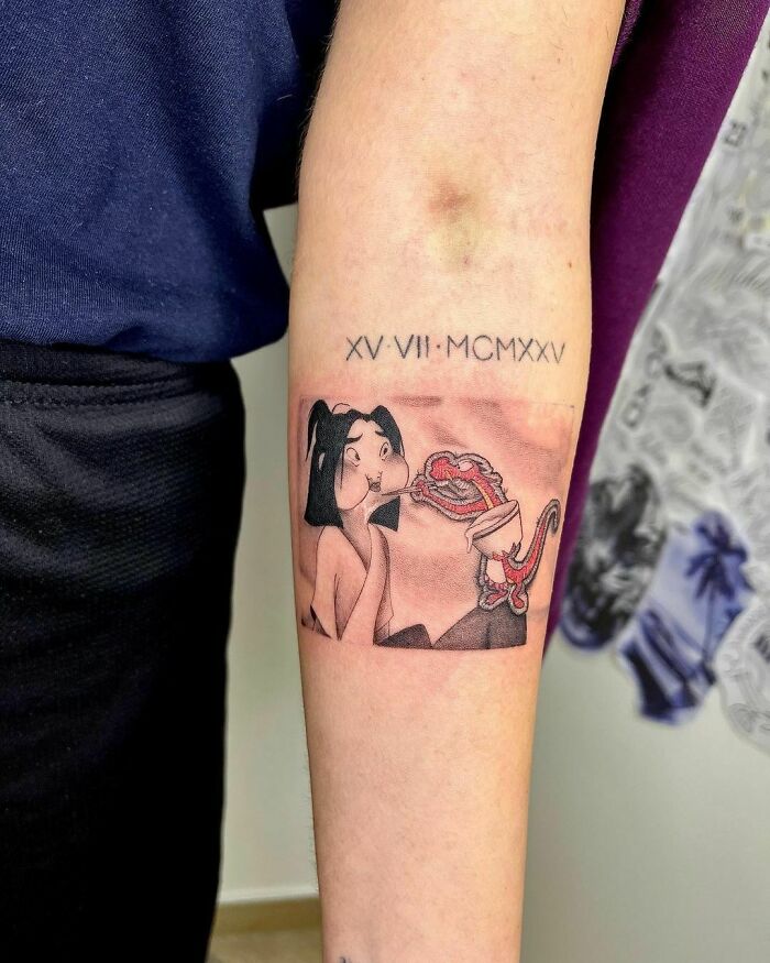 Cartoon tattoo of Mulan and Mushu on arm, showcasing nostalgic Disney characters.