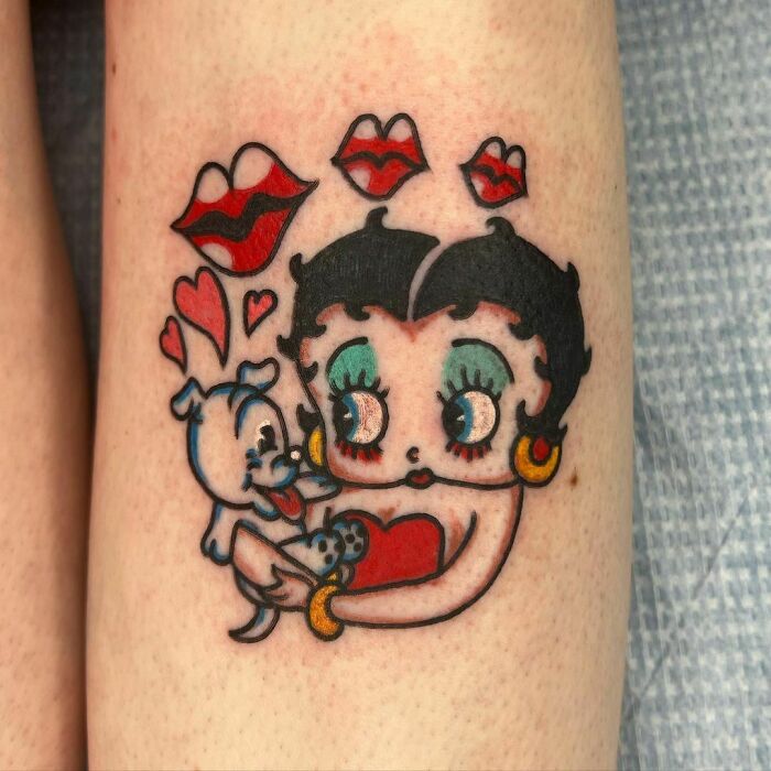 Cartoon tattoo featuring a classic animated character with puppy and hearts, evoking childhood favorites.