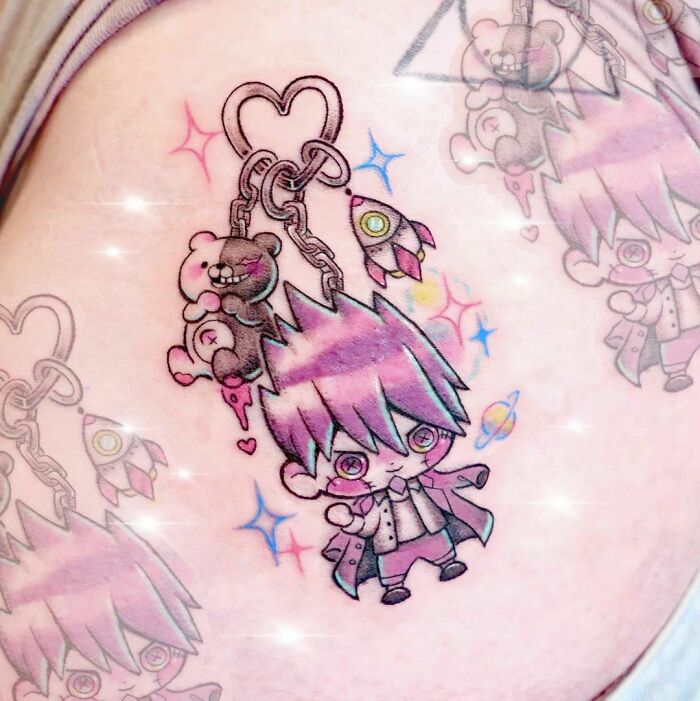 Cartoon tattoo featuring a cute character with pink hair, surrounded by hearts, bears, and rockets.