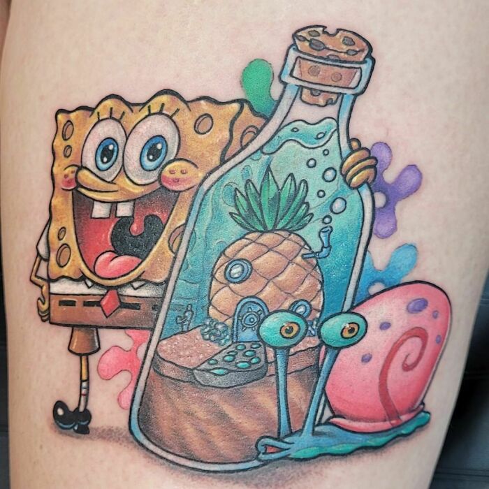 Cartoon tattoo featuring a cheery character and underwater scene, evoking childhood favorites with vibrant designs.