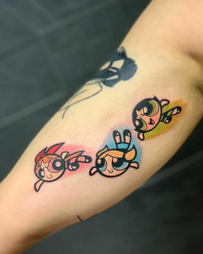 Cartoon tattoos featuring iconic childhood characters from a popular animated series, vibrant and nostalgic on a forearm.