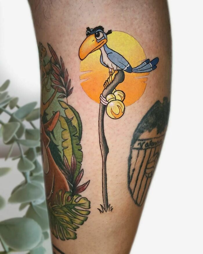 Cartoon tattoo of a bird on a branch with a sunset background, inspired by favorite animated shows.