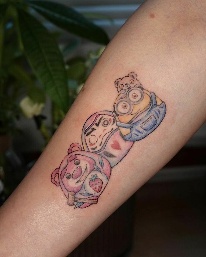 Cartoon tattoo featuring characters from animated shows on forearm.