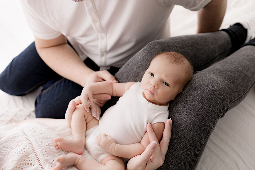 A photograph of a newborn with their parents