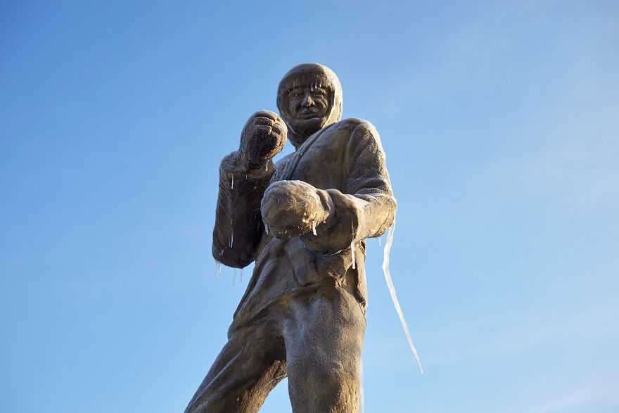 Sculptures Of Athletes Covered With Ice After An Icy Rain