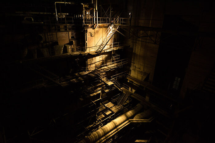 Dimly lit industrial structure at night in an abandoned place, captured with extensive use of light and shadows.