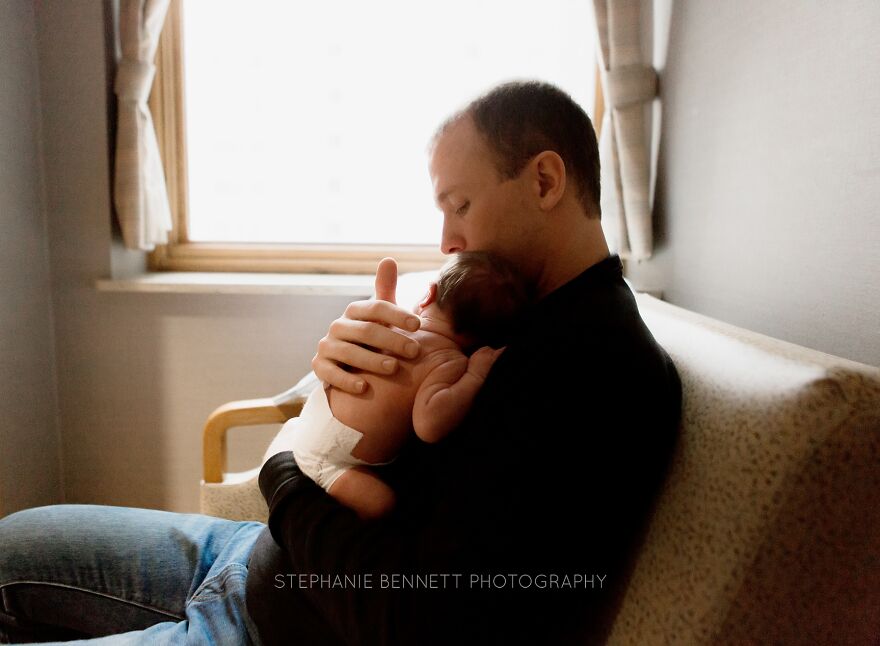 A photograph of a newborn with their dad