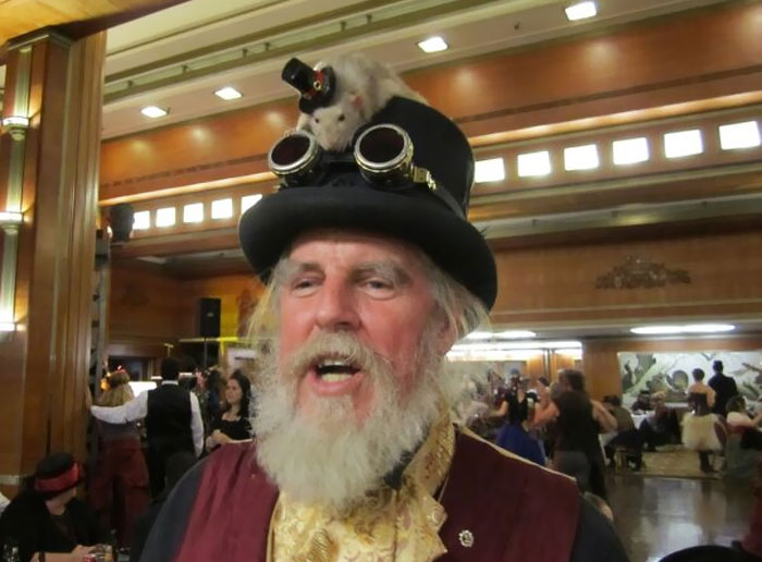 A Real Rat With A Top Hat On The Top Of This Man's Top Hat