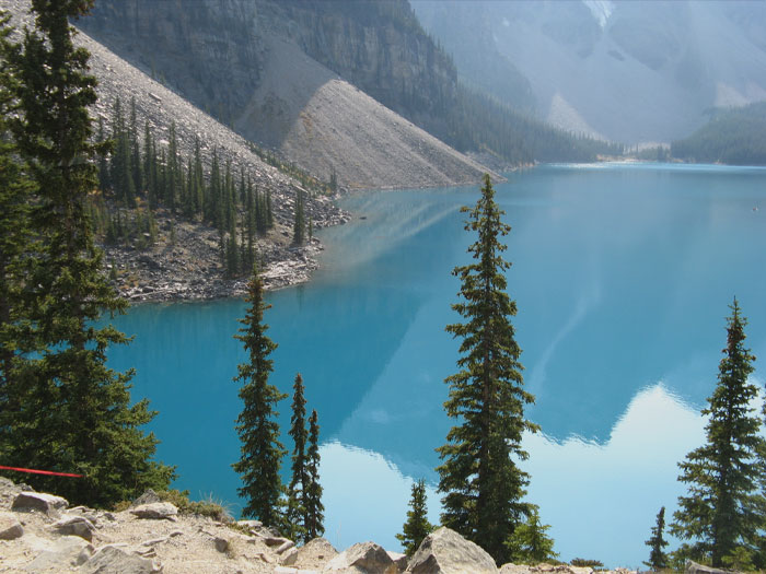 Lake in Canada with trees near and mountains