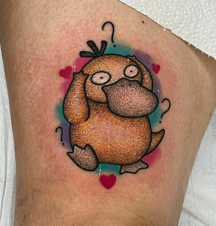 Cartoon-style glitter tattoo of a quirky duck character with hearts and question marks, showcasing unique tattoo art.