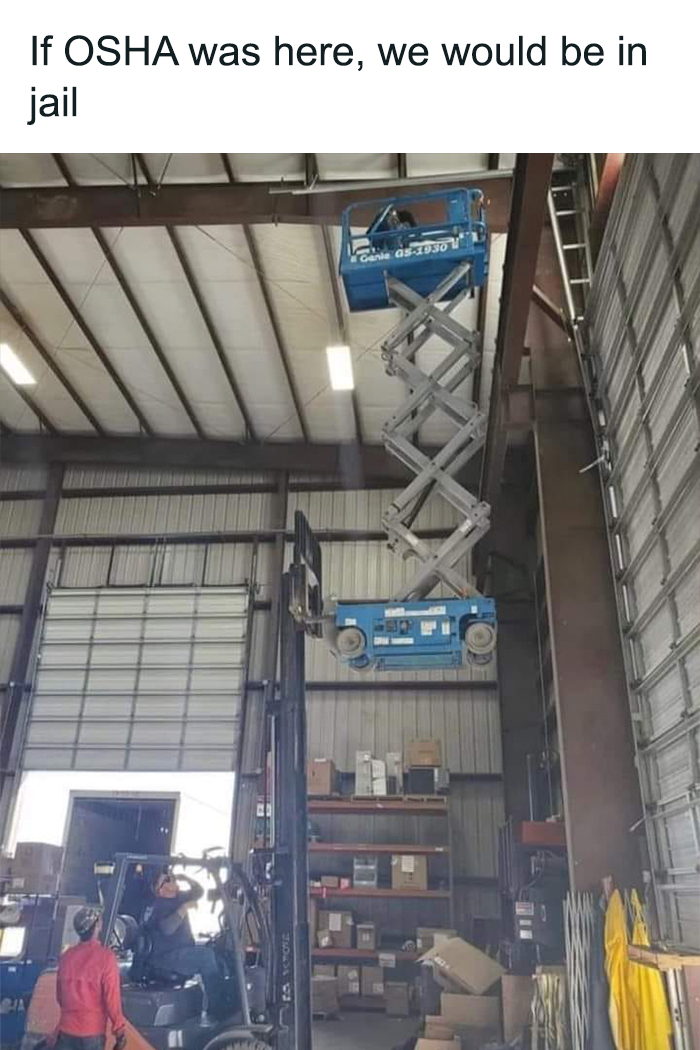 Worker on forklift platform ignores OSHA safety, using precarious lift in warehouse.