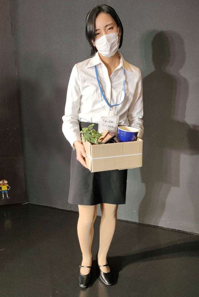 Person in a white shirt and mask holding a box, representing a mundane Halloween costume concept.