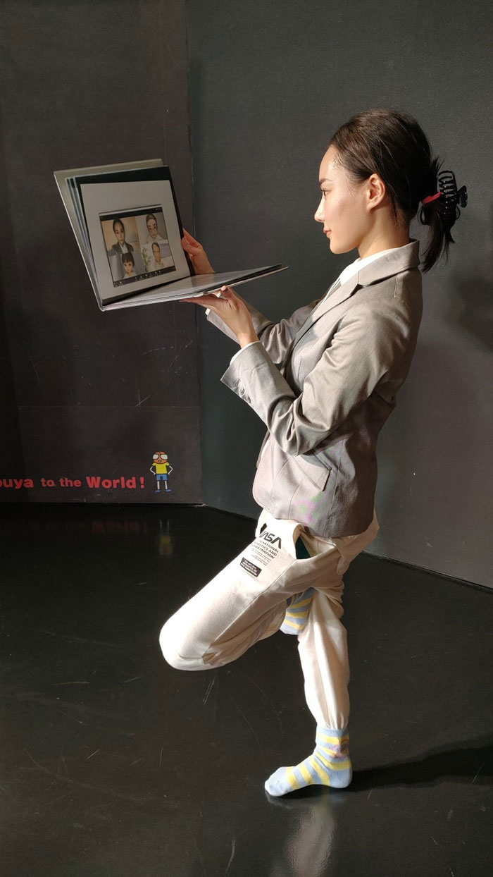 A woman in a suit and socks poses as a video conference call, capturing the idea of mundane Halloween costumes.