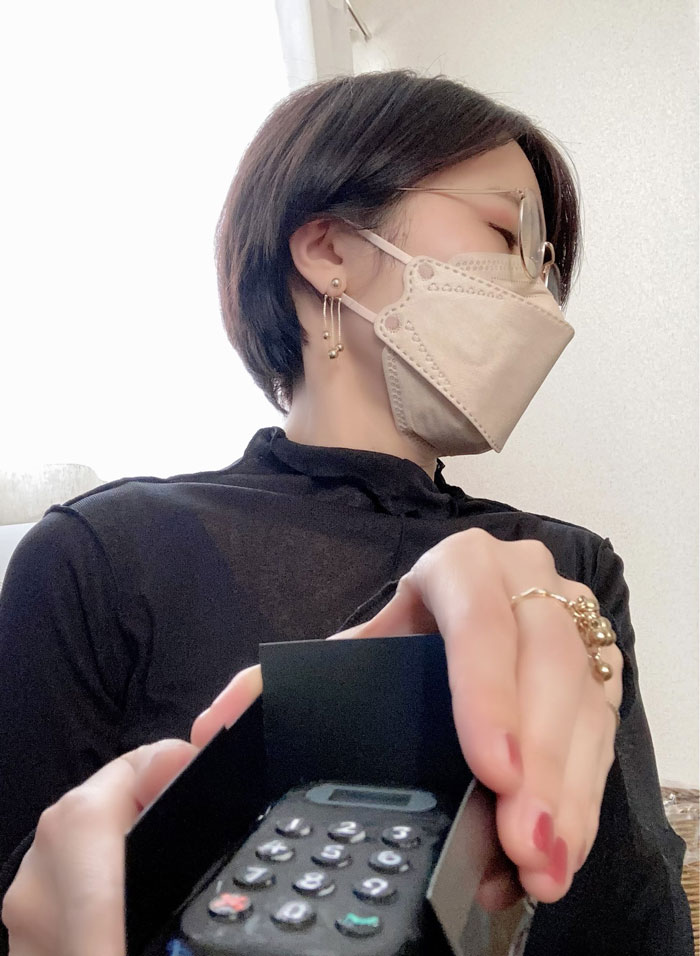 Person in mask with glasses holding a small calculator, showcasing mundane Halloween costume idea.