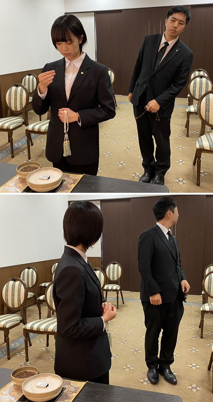 Two people in suits attending a mundane Halloween event, engaging in a casual conversation in an office setting.