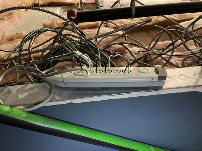 Power strip with tangled wires, showcasing disregard for OSHA safety regulations.