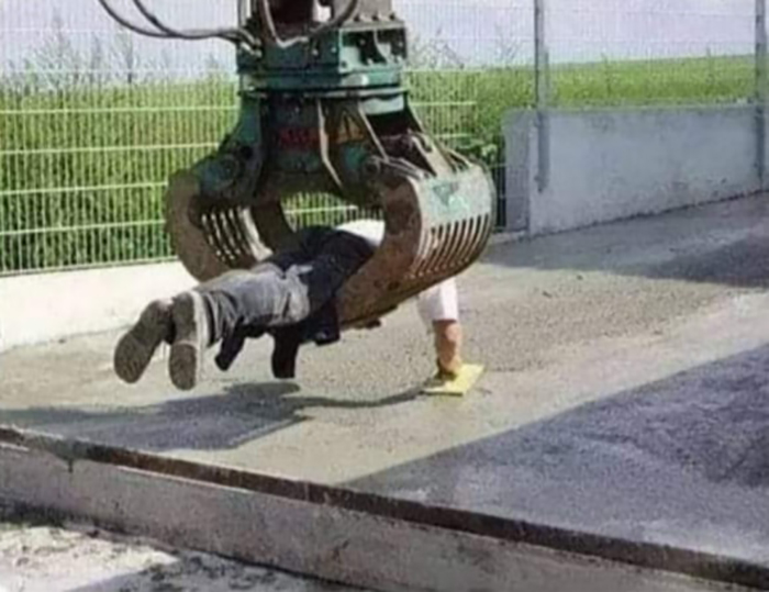 Person caught in a large industrial claw, creatively working around safety standards.