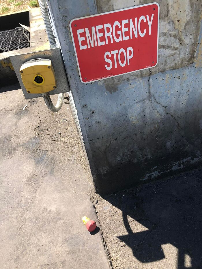 Emergency stop sign with button on ground, highlighting ignored OSHA safety regulations.