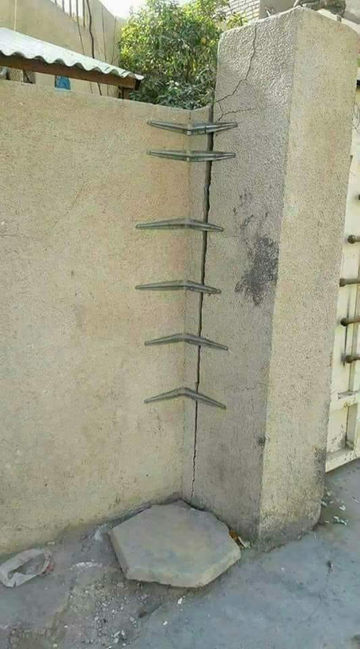 Improvised wall ladder with metal bars, disregarding OSHA safety regulations.
