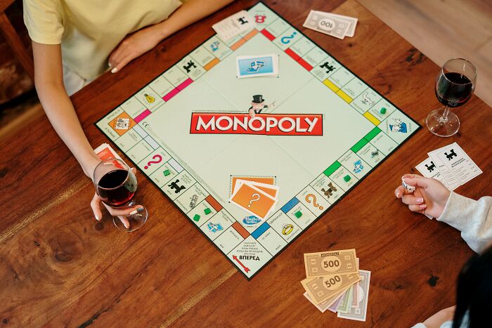 Friends Playing Monopoly And Drinking Wine 