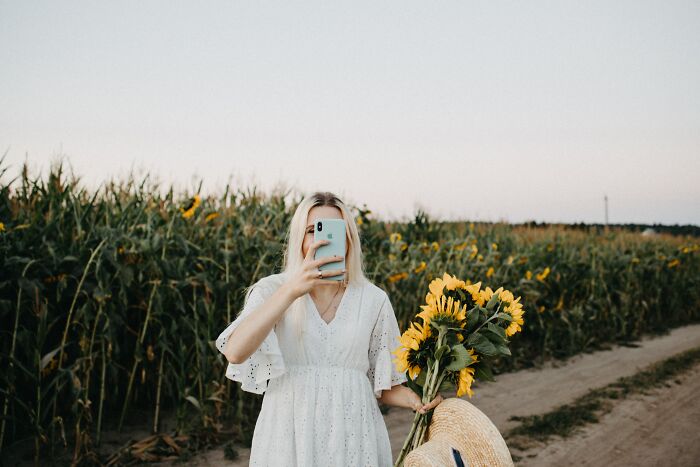 Woman Taking Photos In Sunflower Fields 