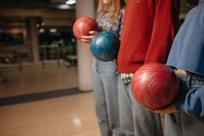 Three Girls Holding A Bowling Ball 