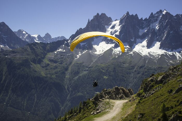 Person Paragliding From The Mountain Top 