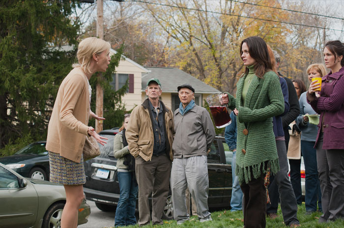 Two woman arguing and a bunch of people looking at them 