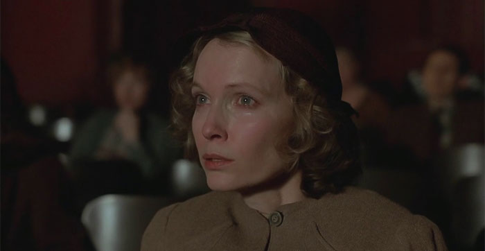 Woman looking at cinema screen and crying 