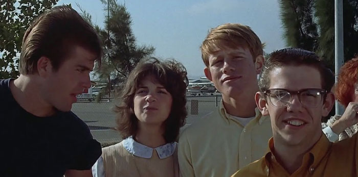 Three man and woman smiling at the parking lot 