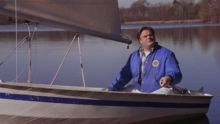 Man with blue coat in a boat in the middle of the lake 