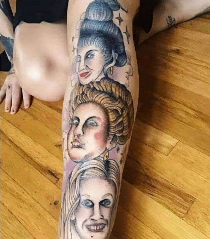 Unusual tattoos with three faces on a person's leg, shared in a Facebook group.