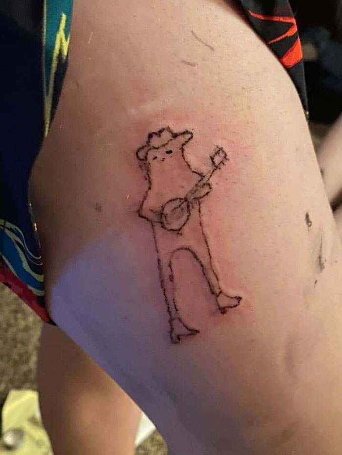 Poorly drawn tattoo of a cartoon character playing a banjo on a person's arm.