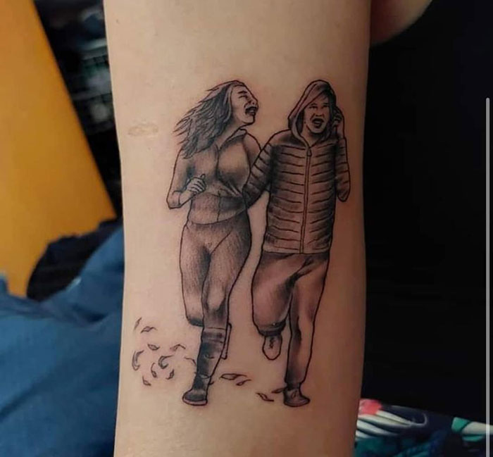 Tattoo featuring two people walking, noted for being poorly executed.