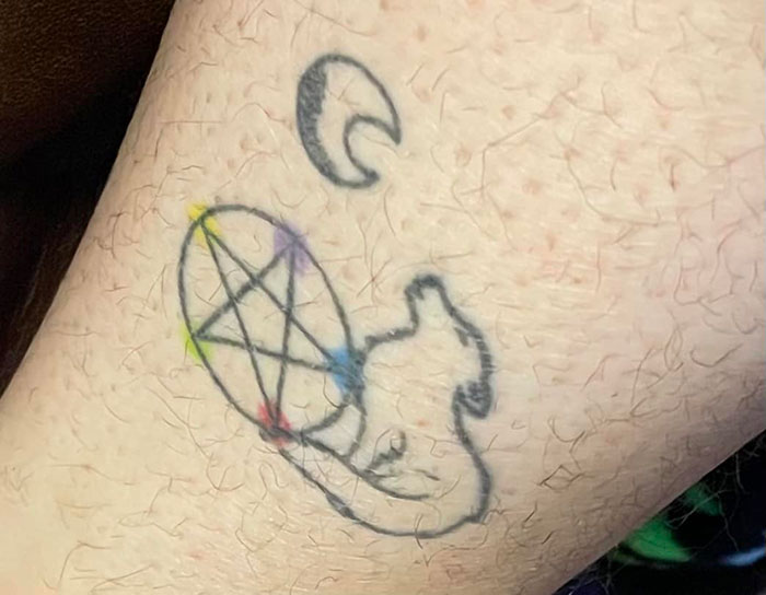 Bad tattoo with a poorly drawn pentagram and abstract shapes in faded ink.