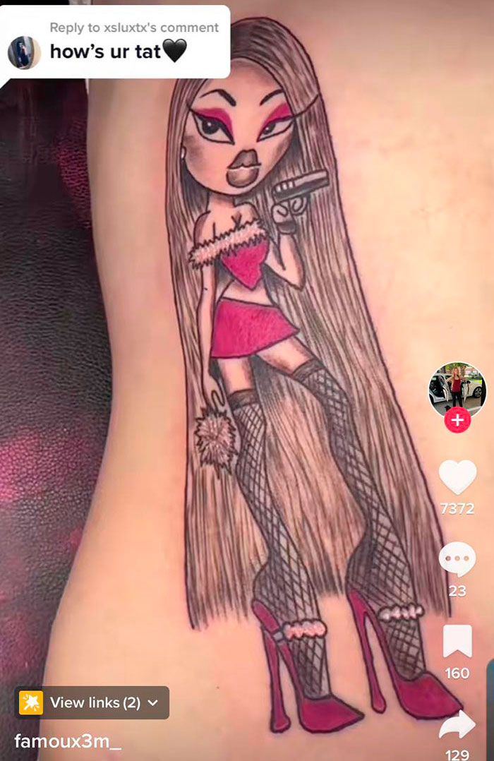 Tattoo depicting a cartoon woman with long hair in a red outfit and high heels, holding a gun, shared on social media.