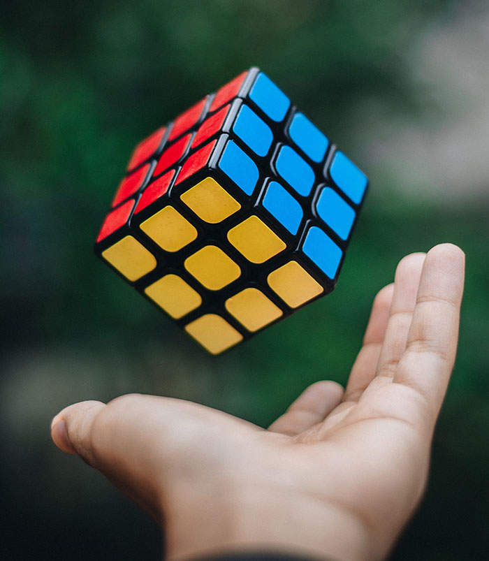 Person tossing a Rubik's cube, ideal solo activity for some "me time" or self-reflection moments.