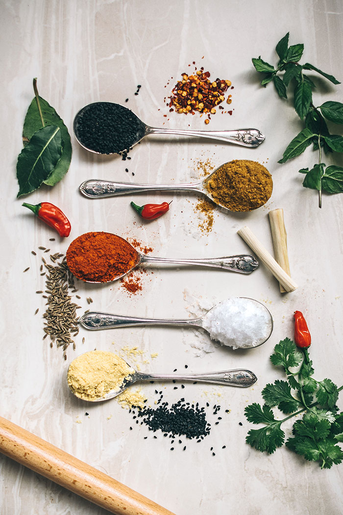 Spices variety displayed in spoons, ideal for a solo cooking activity.