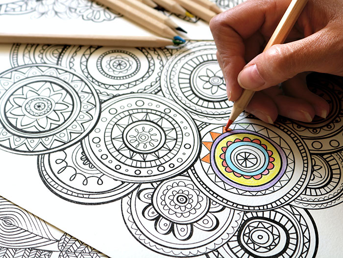 Person coloring intricate mandala patterns, illustrating a relaxing solo activity for creative "me time."