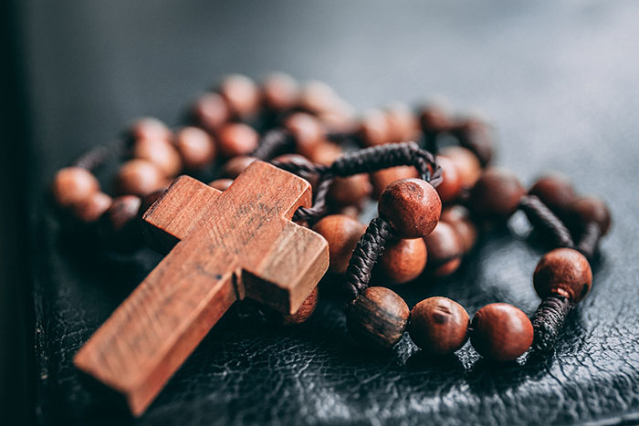Wooden cross necklace resting on a surface, symbolizing personal reflection and "me time" activities.