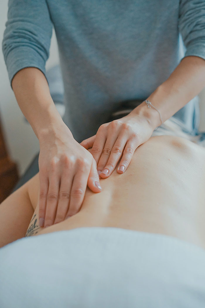 "Massage therapy for relaxation and self-care, focusing on hands applying pressure on a person's back."